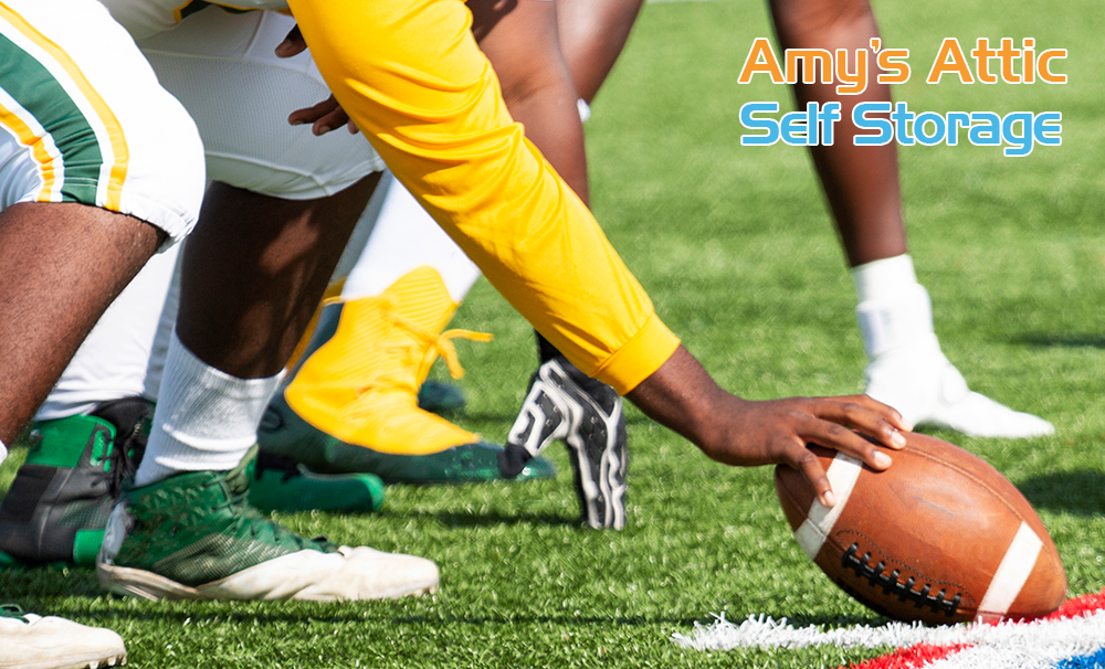 football player holding ball to ground